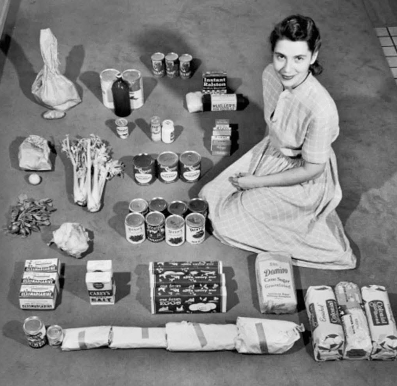 A housewife poses with $12.50 worth of groceries for the week in 1947 